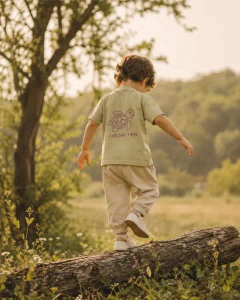 Child in a yellow raincoat exploring outdoors