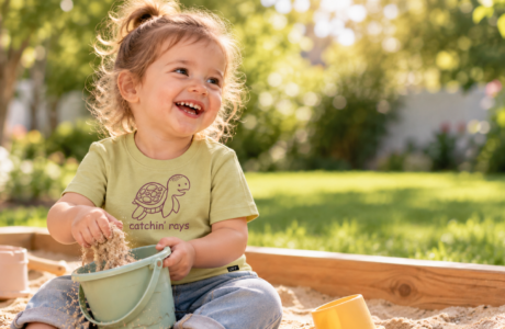 Toddler in an organic cotton UPF 50+ long-sleeve tee playing outside on a sunny playground